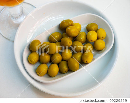 Bunch of marinated green olives on table Bunch of marinated green olives on table 99229239