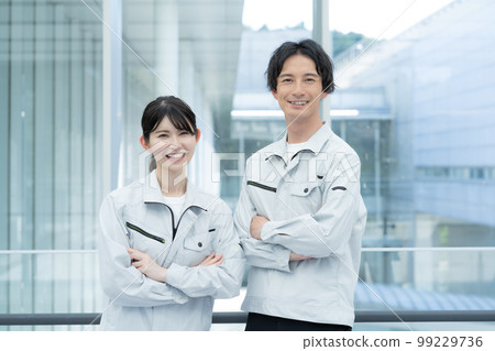 Portrait of two young male and female workers 99229736