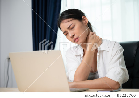 Young asian woman feeling pain in neck and shoulder after working on computer laptop for a long time Young asian woman feeling pain in neck and shoulder after working on computer laptop for a long time 99229760