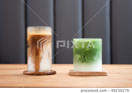Iced coffee latte and iced matcha greentea on wooden table Iced coffee latte and iced matcha greentea on wooden table 99230279
