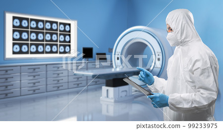Doctor wears medical protective suit or coverall suit with x-ray brain and mri scan machine 99233975