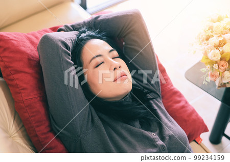 sleeping on the sofa woman relaxing sleeping on couch at home, relaxed serene pretty young woman feel fatigue lounge on comfortable sofa rest at home, happy calm lady dream enjoy wellbeing take a rest 99234159