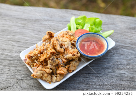 Fried pork intestine with garlic with sauce on plate - pork offal Thai food or snacks Fried pork intestine with garlic with sauce on plate - pork offal Thai food or snacks 99234285