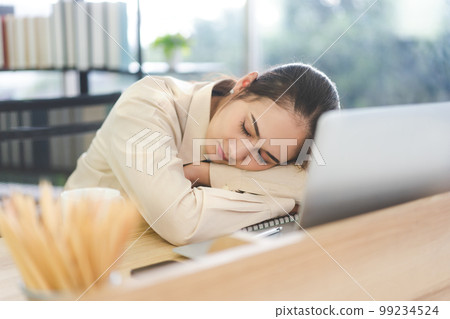 Young adult business asian woman fatique and sleep on table at office 99234524