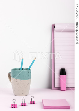 Coffee Cup Standing on Desk. Important infrormation written on paper. Different Office Supplies, Pencils, Pens, Marckers. Computer keyboard. Text on wood table. 99234577