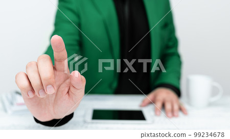 Businessman in Green jacket sitting at table And Pointing With One Finger On Important Message. Gentleman Showing Critical Announcement. Phone on table. 99234678