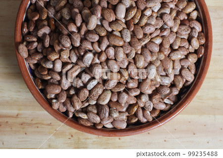 Dry Pinto Beans in Clay Bowl With Wooden Spoon in Rustic Kitchen Dry Pinto Beans in Clay Bowl With Wooden Spoon in Rustic Kitchen 99235488