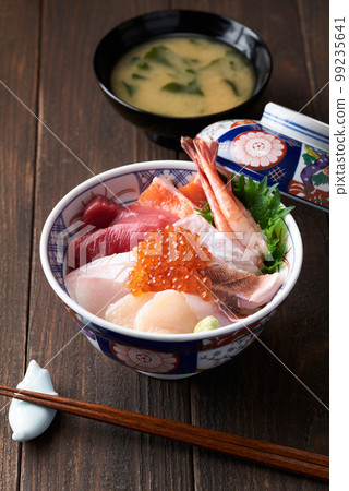 Bowl of rice topped with sashimi  99235641