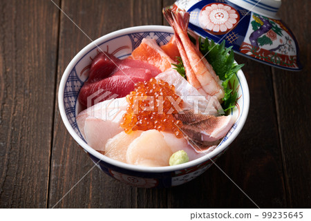 Bowl of rice topped with sashimi  99235645