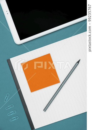 Mobile Phone Lying on Desk. Important infrormation written on colored paper and notebook. Different Office Supplies, Pencils, Pens, Marckers. Computer keyboard. 99235767