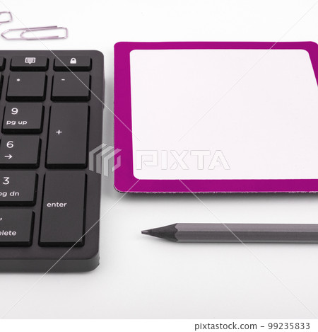 Colored paper with important message lying desk near keyboard. Main information written on notebook. School supplies. Multiple Assorted Collection Office Stationery. Colored paper with important message lying desk near keyboard. Main information written on notebook. School supplies. Multiple Assorted Collection Office Stationery. 99235833