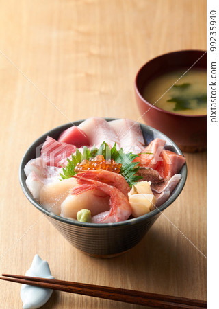 Bowl of rice topped with sashimi  99235940