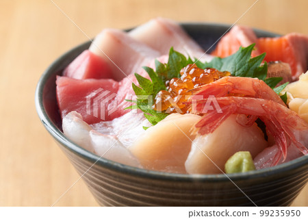 Bowl of rice topped with sashimi  99235950