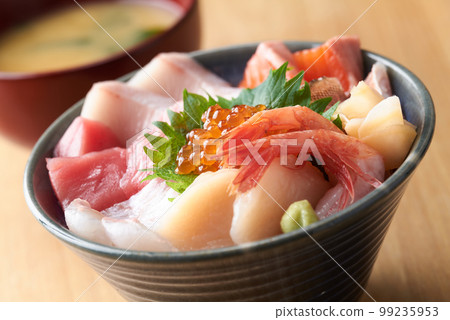 Bowl of rice topped with sashimi  99235953
