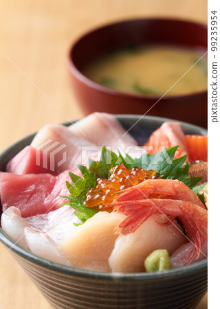 Bowl of rice topped with sashimi  99235954