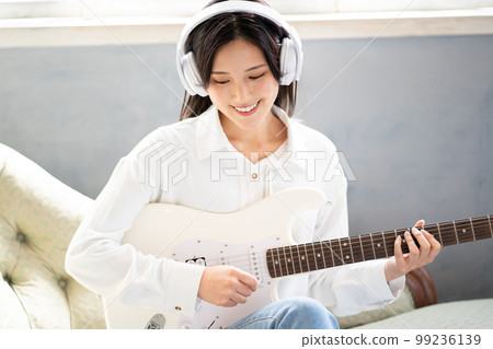 Young woman portrait (electric guitar & headphones) 99236139
