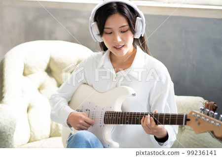 Young woman portrait (electric guitar & headphones) Young woman portrait (electric guitar & headphones) 99236141