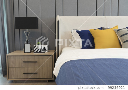 A large double bed with pillows and a bedspread. Lamps with lampshades on the bedside tables. A large double bed with pillows and a bedspread. Lamps with lampshades on the bedside tables. 99236921