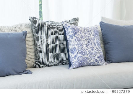 Sofa with flowery and blue rustic pillows in white living room Sofa with flowery and blue rustic pillows in white living room 99237279