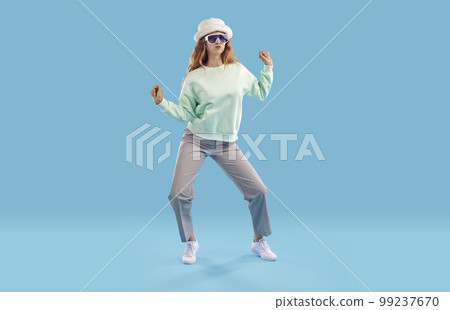 Portrait of cheerful, funny and active woman in good mood having fun on light blue background. 99237670