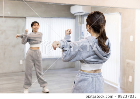 在舞蹈室裡,年輕女子伸向鏡子 舞蹈嘻哈形象 在舞蹈室裡,年輕女子伸向鏡子 舞蹈嘻哈形象 99237833