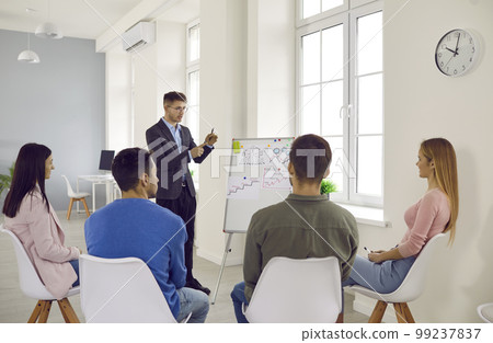 Businessman making presentation to his colleagues during meeting or in-house business training. 99237837