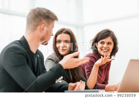 young people discussing something sitting at the table 99238059