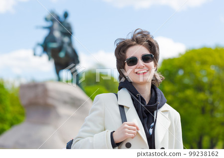 Portrait young european tourist in sunglasses, wearing white coat and black Portrait young european tourist in sunglasses, wearing white coat and black 99238162