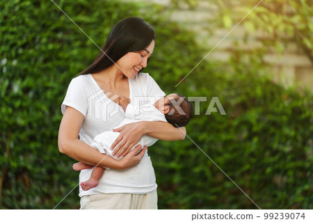 mother holding with her baby newborn in garden mother holding with her baby newborn in garden 99239074