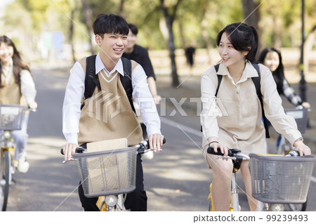 Happy teenager students riding bicycle the school Happy teenager students riding bicycle the school 99239493