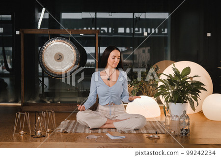 A young woman sitting in the Lotus position before the Game was playing and holding game cubes in her hand 99242234