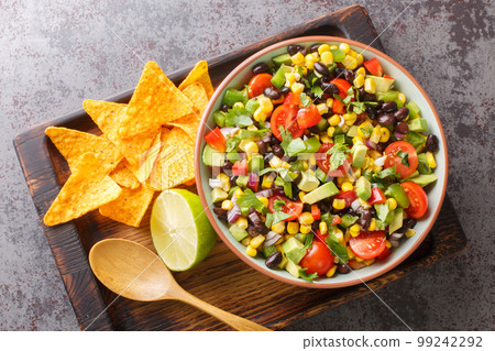 Homemade Cowboy salad or Texas caviar bean dip lime dressing, served with tortilla chips closeup in the bowl. Horizontal top view Homemade Cowboy salad or Texas caviar bean dip lime dressing, served with tortilla chips closeup in the bowl. Horizontal top view 99242292