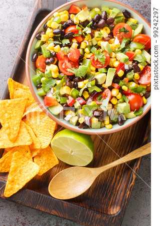 Organic Cowboy Caviar Dip with vegetables and Chips closeup in the bowl. Vertical top view Organic Cowboy Caviar Dip with vegetables and Chips closeup in the bowl. Vertical top view 99242297