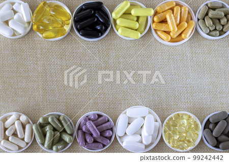 Mixed pill background, top view. Nutritional supplements, vitamins and organic minerals. on a beige background. Copy space. Frame made of tablets. Mixed pill background, top view. Nutritional supplements, vitamins and organic minerals. on a beige background. Copy space. Frame made of tablets. 99242442
