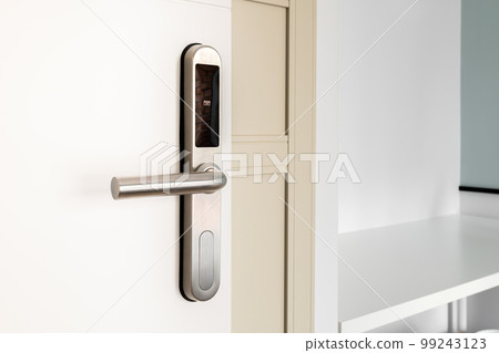 Open front door with electronic mortise lock and handle. The door is opened with a combination of a digital code or a plastic card. Modern door opening and property security systems. 99243123