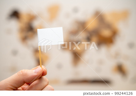White flag with copy space in man hands with world map on the background. 99244126