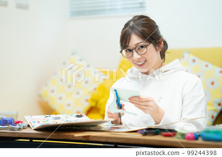 woman making a scrapbook woman making a scrapbook 99244398