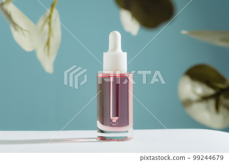 Pink face and hair oil on blue background with green Eucalyptus Pink face and hair oil on blue background with green Eucalyptus 99244679