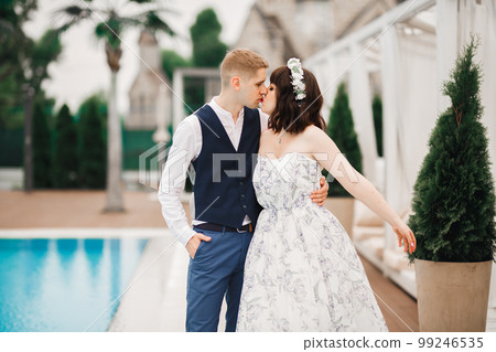 Beautiful bride and groom embracing and kissing on their wedding day 99246535