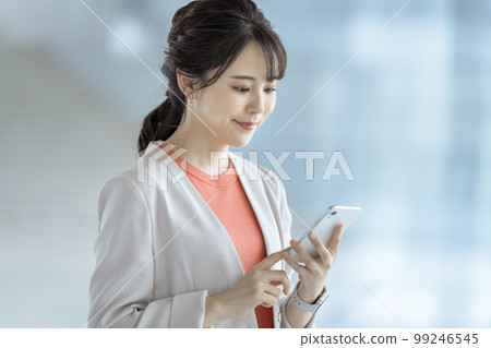 Business woman operating a smartphone 99246545