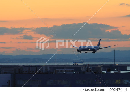 Passenger planes landing against the backdrop of the sunrise Early morning arrivals at Haneda Airport 99247444