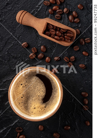 Coffee cup and beans in a scoop, shot from above 99247738