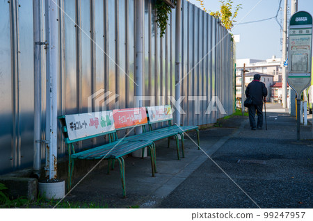 A person getting off the bus and heading home from the bus stop 99247957