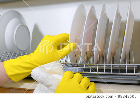 House cleaning, closeup of hands with a rag wiping dishes in the kitchen 99248503