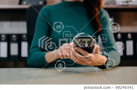 SDK  Software development kit programming language technology concept, Person typing laptop computer and tablet with SDK icon on virtual screen. in office. 99249341