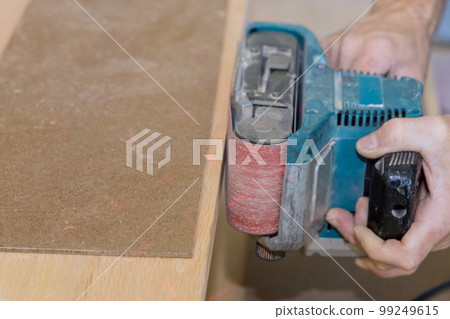 In carpenter works process of building new house grinding the wooden staircase 99249615