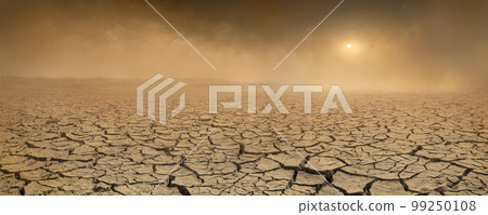 Wide panorama of barren cracked land with sun barely visible through the dust storm. Drought and desertification concept 99250108