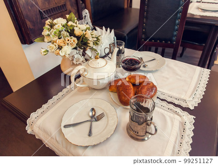 A set table for tea drinking in retro style of USSR times with baked pies. A set table for tea drinking in retro style of USSR times with baked pies. 99251127