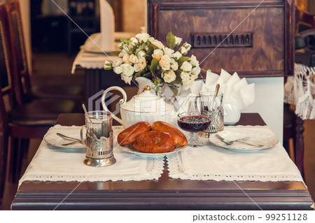 A set table for tea drinking in retro style of USSR times with baked pies. 99251128