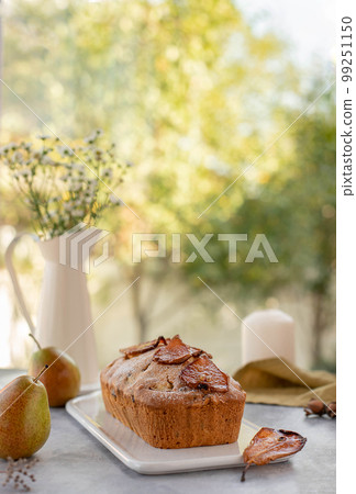 muffin cake with pears, nuts on a window background. 99251150